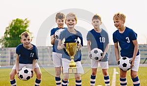 Young players ofÂ soccer team lift up the golden cup trophy